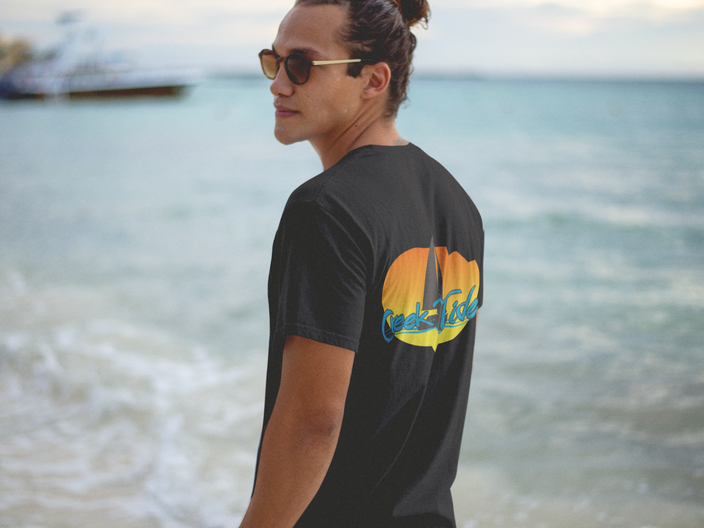 t shirt mockup of a hipster guy wearing sunglasses at the beach shore