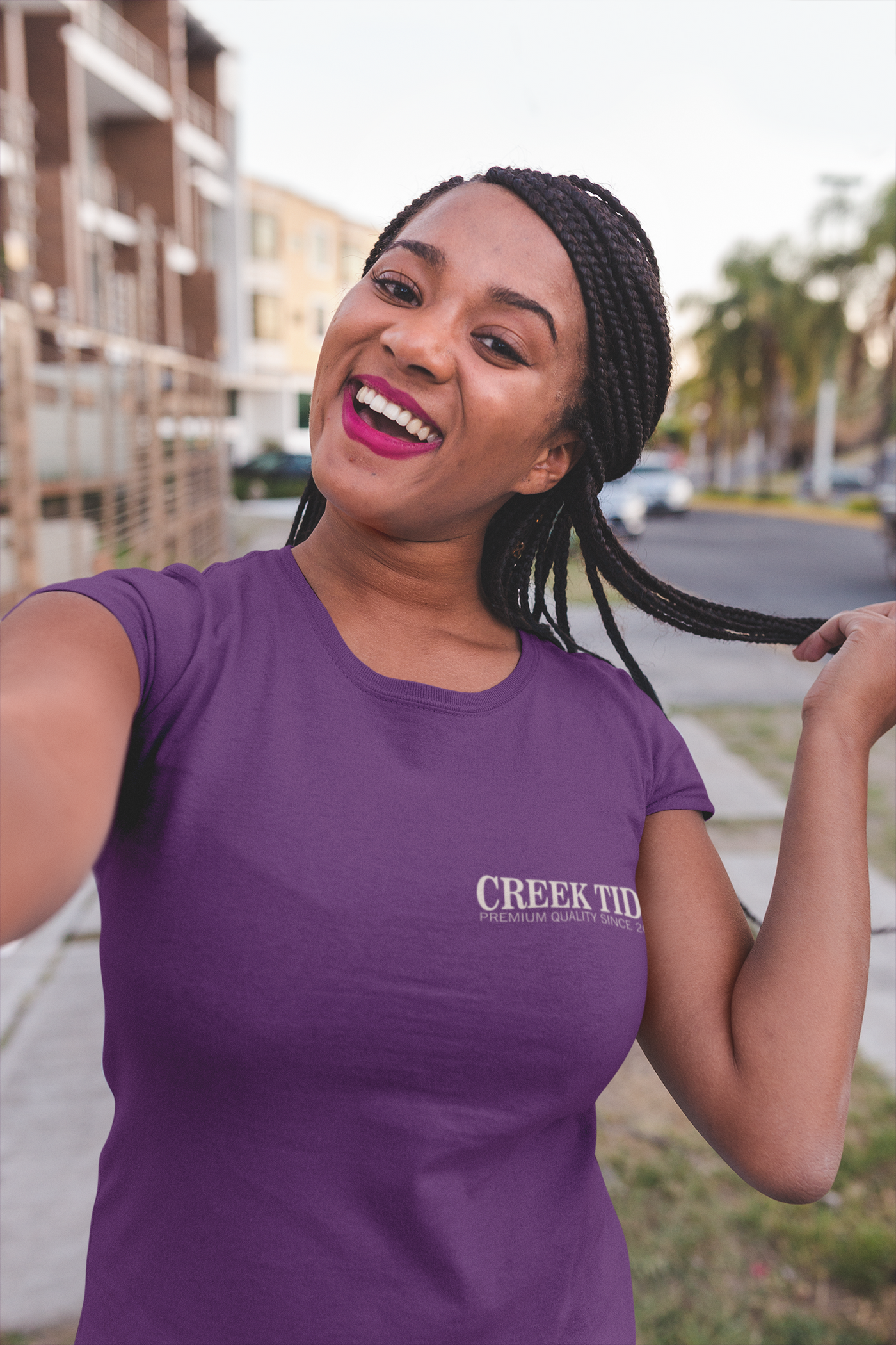 t shirt mockup of a girl with braids happily taking a selfie on the street